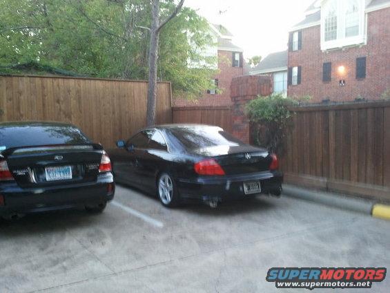 Black Subaru Legacy wagon parked next to a black Acura coupe