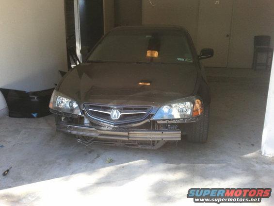 Dark sedan with missing front bumper, front view. Appears to be a 2004 Acura TL