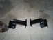 1992 Ford Bronco - A pair of black metal brackets with rubber isolators are shown on a concrete surface.