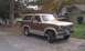 1984 Ford Bronco - This two-tone brown and tan 1984 Ford Bronco is parked outside a garage.
