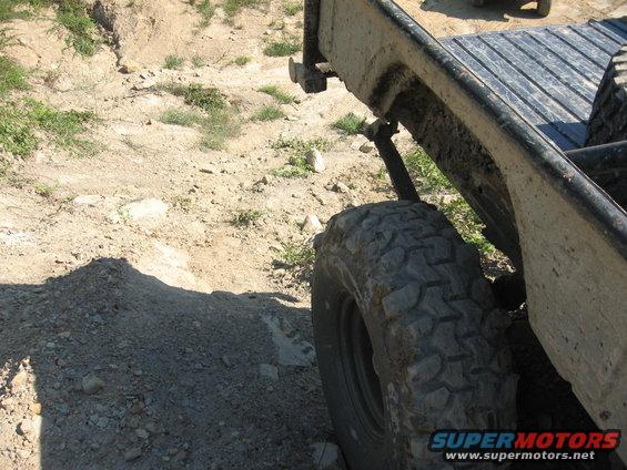 Off-road vehicle's rear tire and fender on a dirt track