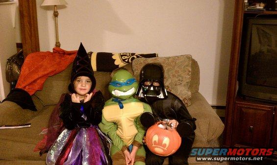 Children in Halloween costumes sit on a couch