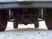 1993 Ford Bronco - A low-angle shot reveals the underside of a vehicle, focusing on its mechanical components and tires.
