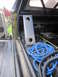 1974 Ford Bronco - Rolled blue hose and metal bracket inside a vehicle's cargo area.