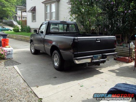 Black pickup truck parked in a driveway, rear view