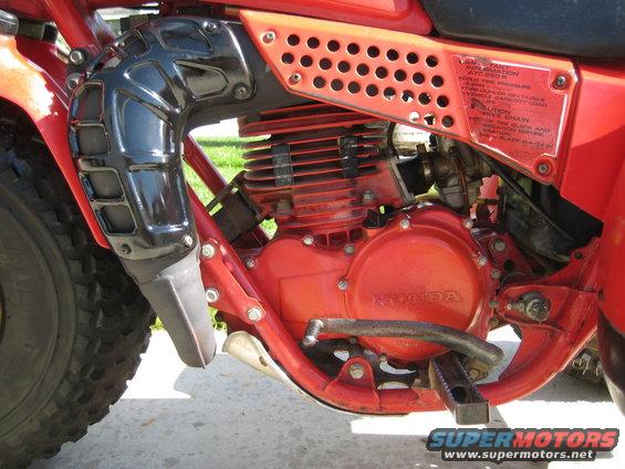 Red Honda ATC 250R engine and exhaust system, close-up side view