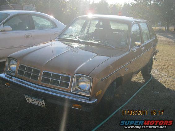 Brown 1980s Chevrolet Chevette hatchback parked next to a white sedan. License plate reads 023-GYA