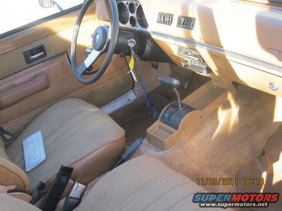 Interior of a car with tan seats, steering wheel, and dashboard. Automatic shifter is visible