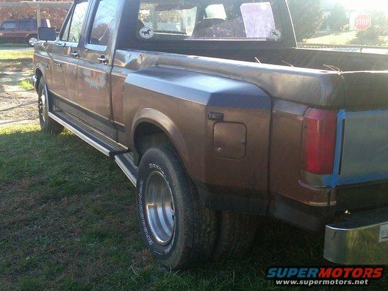 Brown Ford F-350 dually truck, rusty, with chrome step bars and dual rear wheels