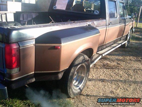 Brown 1988 Ford F-350 dually truck rear view with exhaust smoke