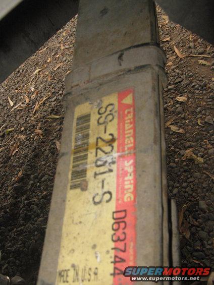 Leaf spring with a yellow label showing 'SS-2281-S' and a red label with 'TRIANGLE SPRING' and 'D637444'