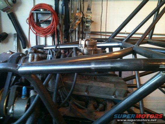 Engine block and roll cage tubing in a workshop setting