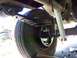 1989 Ford Bronco - Underside view of a vehicle's rear suspension components, including the axle, leaf springs, and a white shock absorber.