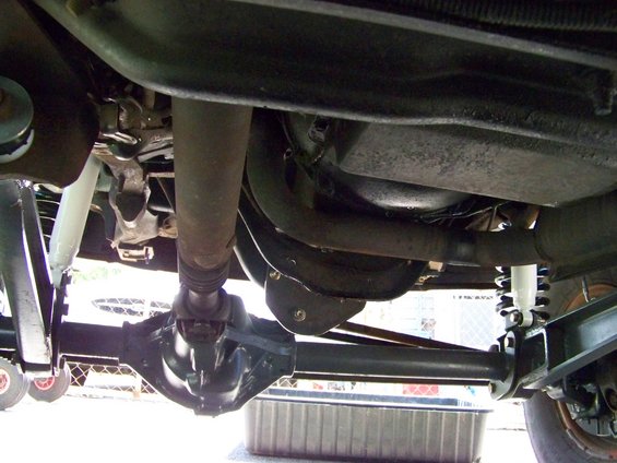 Undercarriage view of a rear axle and driveshaft, possibly from a modified truck or SUV