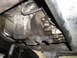 1997 Ford F-250 - Underside view of a vehicle's transmission and transfer case, showing various components and some grime.