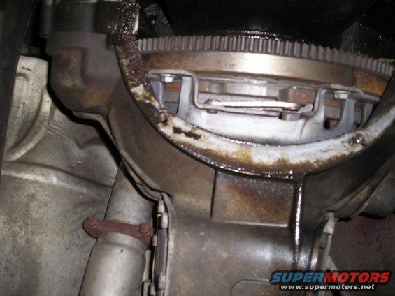 Transmission bell housing with oily residue and a visible flywheel gear