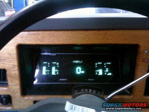 Digital dashboard with wood grain trim, showing 0 miles and 'EE' and '52' indicators