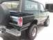 1995 Ford Bronco - This black Ford Bronco is shown from the rear quarter angle, with a spare tire mounted on the back.
