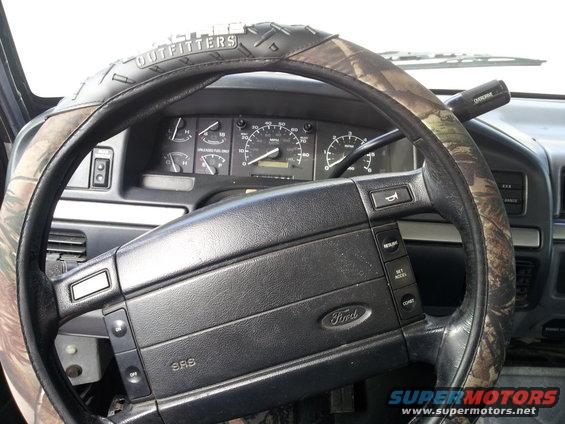 1995 Ford Bronco interior showing steering wheel with camouflage cover, dashboard, and gauges