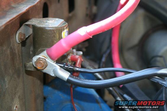 Close-up of a battery cable connected to a terminal with red and black wires