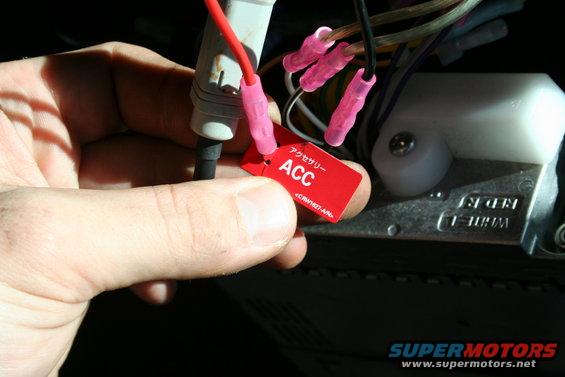 Red ACC tag with Japanese text held by a hand near wiring