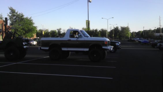 Lifted two-tone 1989 Ford Bronco parked in a lot