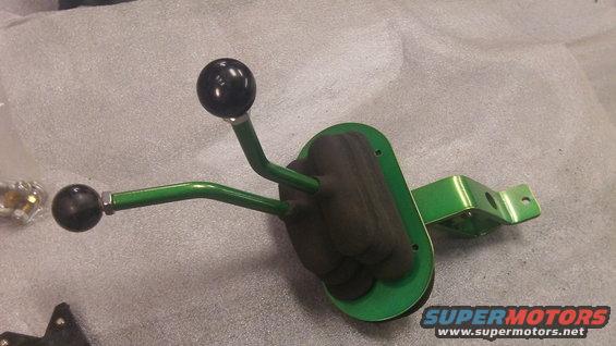 Green dual-lever shifter assembly with black knobs on a gray surface