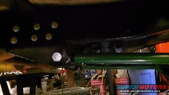Vehicle undercarriage with green suspension and black frame rails