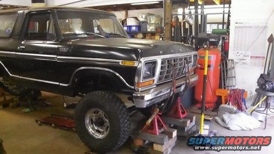 Black Ford Bronco on jack stands in a garage, front end visible