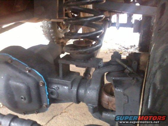 Close-up of black differential housing and coil spring suspension on a vehicle