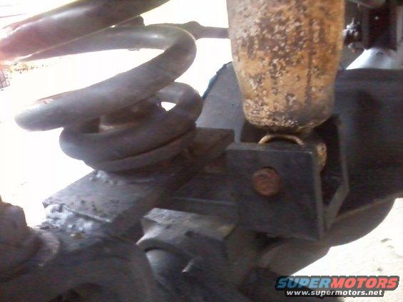 Close-up of rusty shock absorber and coil spring