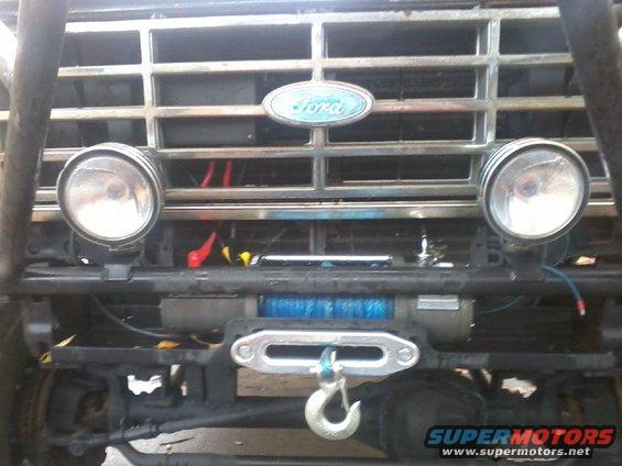 1986 Ford Bronco front grille with Ford oval badge, two round headlights, and a winch mounted below