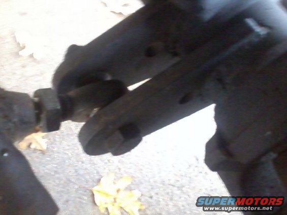 close-up of a vehicle's suspension linkage with a nut and bolt