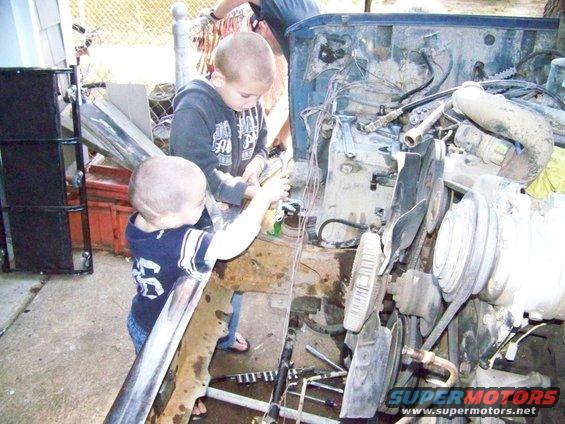 Engine bay with two children working on it