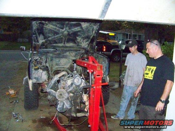 Engine being removed from a truck with an engine hoist