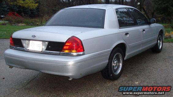 Silver sedan, 2000 Ford Crown Victoria, rear 3/4 view, showing chrome trim and tinted windows