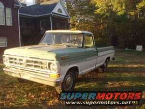 Old Ford pickup truck, two-tone paint, parked outside a house