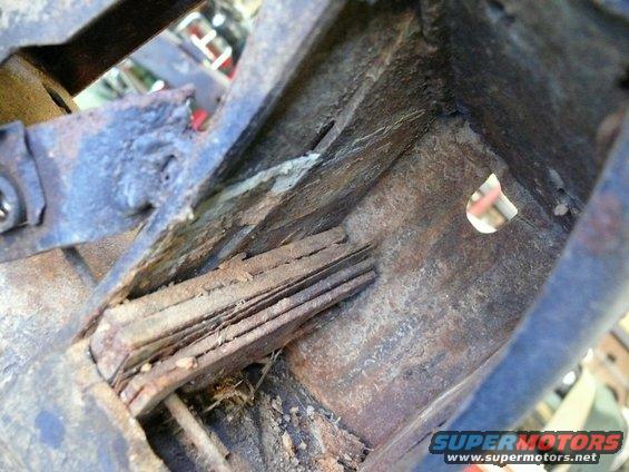 Rusted metal frame with layered wood debris, close-up