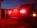 2003 Mercury Marauder - The rear of a Ford Mustang is illuminated by its bright red brake lights at dusk.