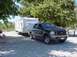 2003 Ford Excursion - Ford Excursion tows a Wildwood trailer in a shaded outdoor area.