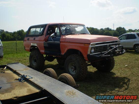 Lifted 1978 Ford Bronco with orange and black paint, off-road tires, and custom bumper
