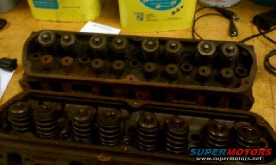 two engine cylinder heads with valves and springs visible