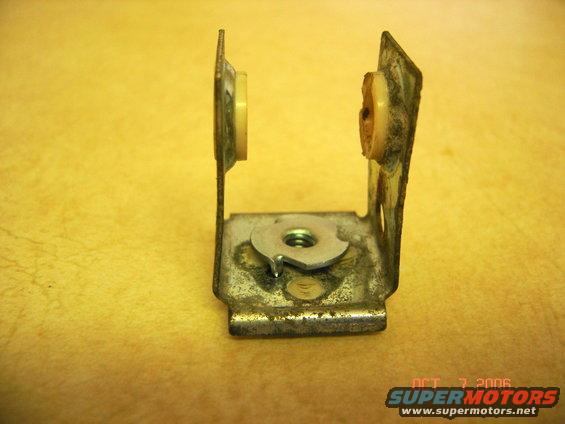 Metal bracket with two plastic bushings and a nut, showing rust and wear. Watermark reads OCT 7 2006 SUPERMOTORS.NET