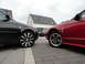 2003 Mercury Marauder - A red Ford Mustang and a dark sedan are parked on a paved driveway in front of a house.