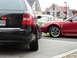 2003 Mercury Marauder - Two cars, a black Audi and a red Ford Mustang, are parked on a paved driveway in front of houses.