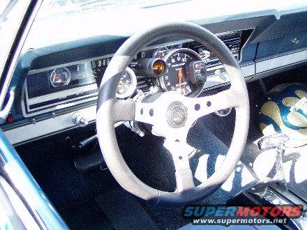 Interior view of a car with aftermarket gauges and steering wheel
