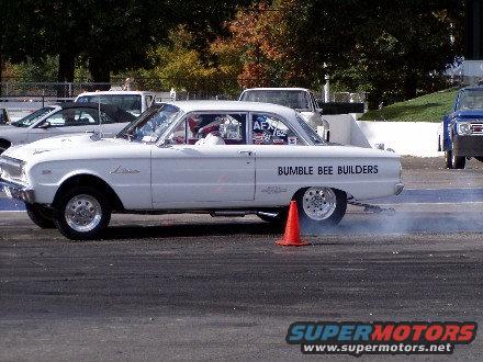 White drag car with 'BUMBLE BEE BUILDERS' on side, doing a burnout