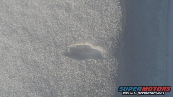 Shadow of a car shape on a snow-covered surface