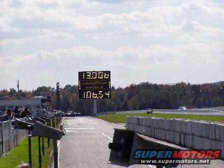 Drag strip with scoreboard showing 130.06 and 106.54, Goodyear Eagle text visible