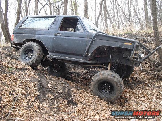 Dark SUV with off-road modifications on a dirt hill
